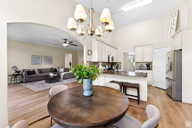 1036 E Fairway Dr, North Salt Lake, UT 84054 - dining area featuring a ceiling fan, a towering ceiling, a chandelier, and light wood-style flooring