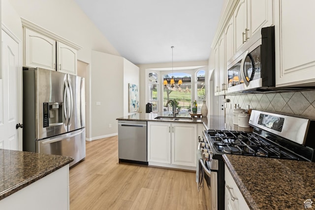 1036 E Fairway Dr, North Salt Lake, UT 84054 - kitchen with stainless steel appliances, a peninsula, light wood-style floors, backsplash, and vaulted ceiling