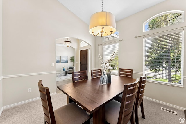 1036 E Fairway Dr, North Salt Lake, UT 84054 - dining room featuring carpet floors, arched walkways, a chandelier, and high vaulted ceiling