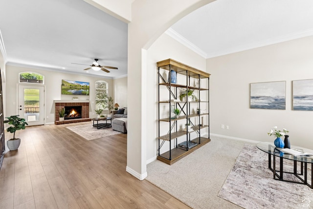 1036 E Fairway Dr, North Salt Lake, UT 84054 - living area featuring crown molding, a ceiling fan, arched walkways, a brick fireplace, and wood finished floors