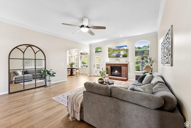 1036 E Fairway Dr, North Salt Lake, UT 84054 - living area with arched walkways, crown molding, light wood finished floors, a ceiling fan, and a brick fireplace