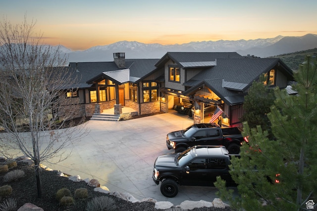 1467 N Chimney Rock Rd, Heber City, UT 84032 - back of property at dusk with a mountain view, driveway, a chimney, and stone siding