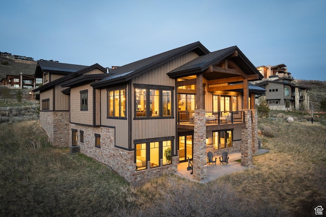 1467 N Chimney Rock Rd, Heber City, UT 84032 - back of house with stone siding, a patio area, and roof with shingles