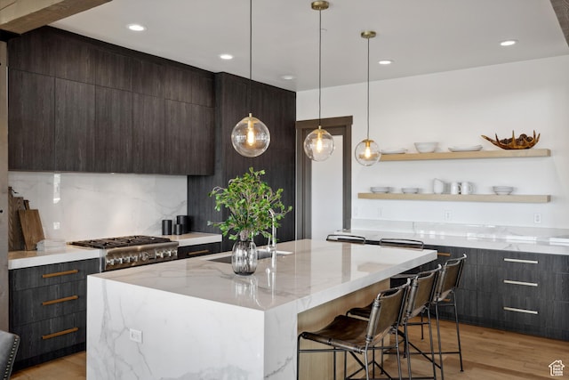 1467 N Chimney Rock Rd, Heber City, UT 84032 - kitchen featuring modern cabinets, dark brown cabinets, light stone countertops, light wood-style flooring, and a kitchen island with sink