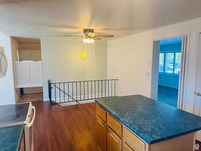 230 E 300 S, Ephraim, UT 84627 - kitchen with electric stove, ceiling fan, dark wood-style flooring, dark countertops, and a kitchen island