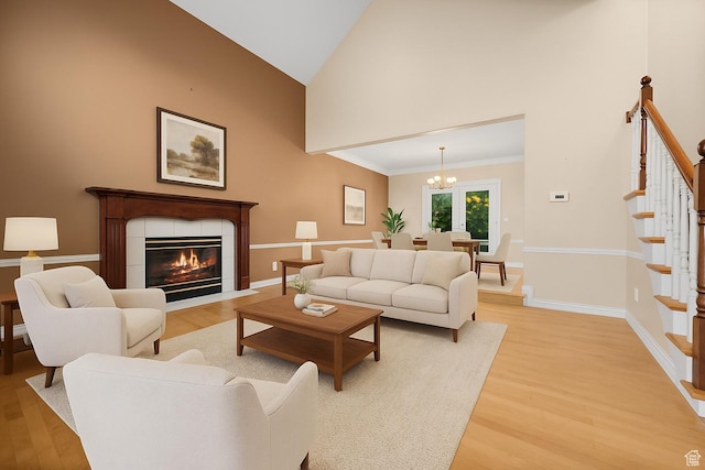 5864 Majestic Pine Dr, Murray, UT 84107 - living area with light wood finished floors, high vaulted ceiling, stairway, a chandelier, and a tiled fireplace