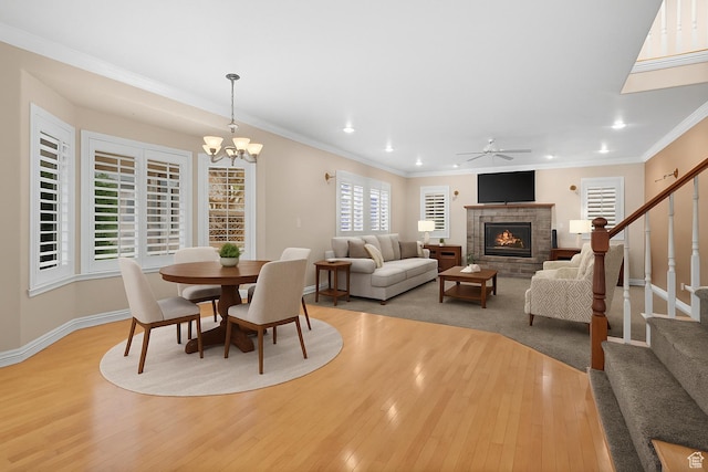 5864 Majestic Pine Dr, Murray, UT 84107 - dining space with light wood finished floors, a fireplace, stairs, recessed lighting, and crown molding