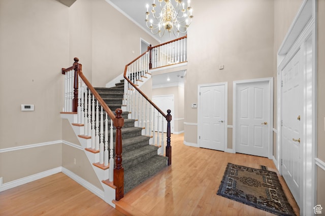 5864 Majestic Pine Dr, Murray, UT 84107 - entrance foyer featuring wood finished floors, stairway, a towering ceiling, and a chandelier