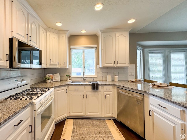 619 W 225 S, Layton, UT 84041 - kitchen with stainless steel appliances, wood finished floors, white cabinets, backsplash, and light stone countertops