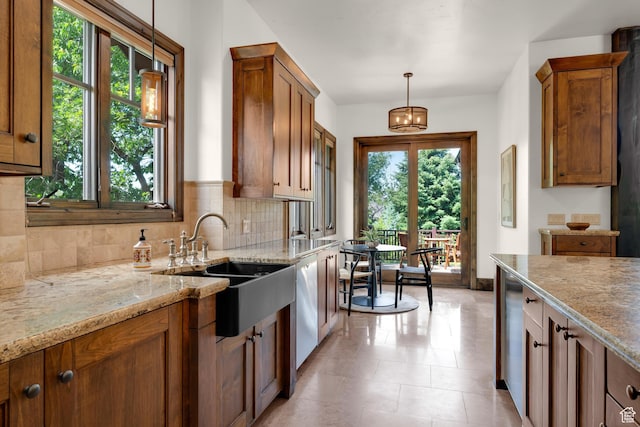 3327 E Wasatch Pines Ln, Sandy, UT 84092 - kitchen with brown cabinets, backsplash, light stone counters, white dishwasher, and decorative light fixtures