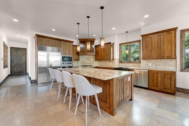 3327 E Wasatch Pines Ln, Sandy, UT 84092 - kitchen featuring built in appliances, brown cabinets, decorative backsplash, an island with sink, and light stone counters