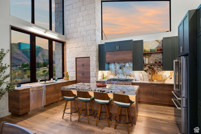 1882 N Main St, Mapleton, UT 84664 - kitchen with stainless steel appliances, light stone counters, light wood-type flooring, and a kitchen breakfast bar