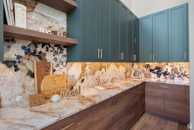 1882 N Main St, Mapleton, UT 84664 - kitchen with open shelves, decorative backsplash, wood finished floors, blue cabinets, and light stone counters