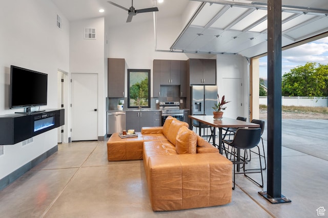 1882 N Main St, Mapleton, UT 84664 - living room featuring finished concrete flooring, a high ceiling, a ceiling fan, plenty of natural light, and recessed lighting