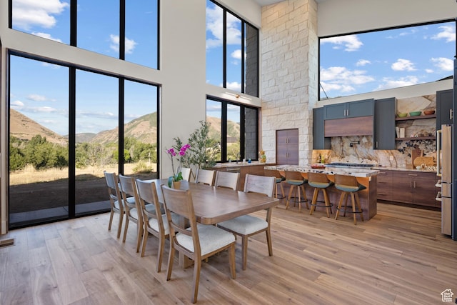 1882 N Main St, Mapleton, UT 84664 - dining area featuring light wood-type flooring, a mountain view, and a towering ceiling