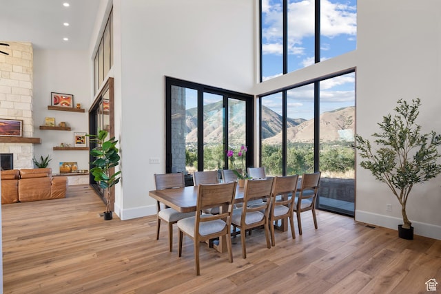 1882 N Main St, Mapleton, UT 84664 - dining room with a towering ceiling, light wood-type flooring, a fireplace, a mountain view, and recessed lighting