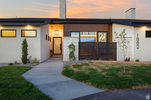 1882 N Main St, Mapleton, UT 84664 - view of front of property featuring a chimney, a lawn, stucco siding, and entry steps