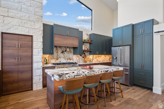 1882 N Main St, Mapleton, UT 84664 - kitchen featuring high end refrigerator, range, tasteful backsplash, a kitchen island, and light wood-style floors