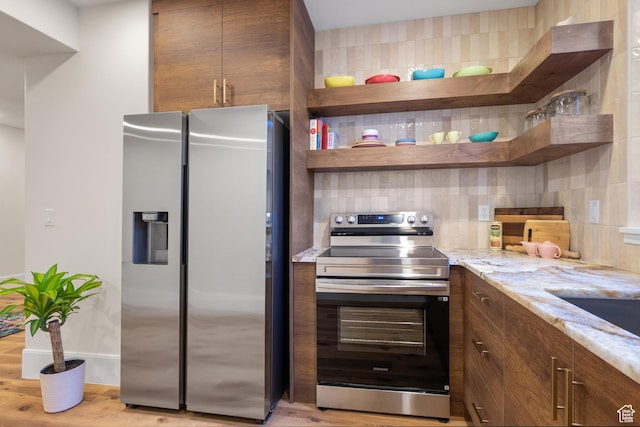 1882 N Main St, Mapleton, UT 84664 - kitchen with appliances with stainless steel finishes, open shelves, backsplash, light stone countertops, and light wood finished floors
