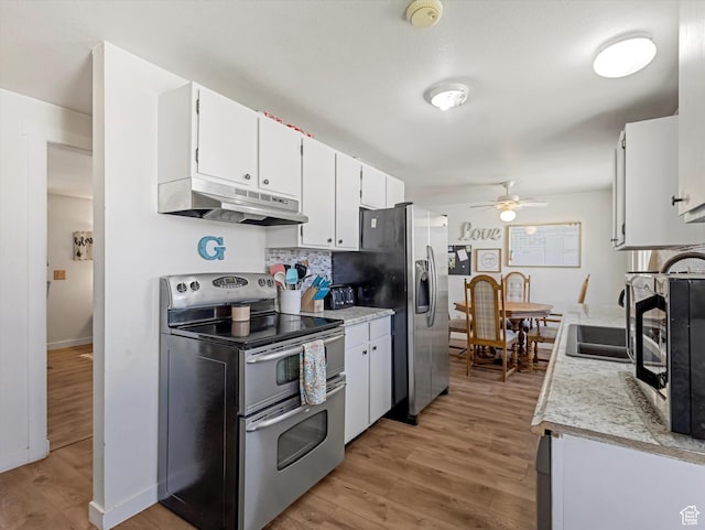 155 Hawthorne, Kamas, UT 84036 - kitchen with appliances with stainless steel finishes, under cabinet range hood, ceiling fan, light countertops, and light wood-style flooring