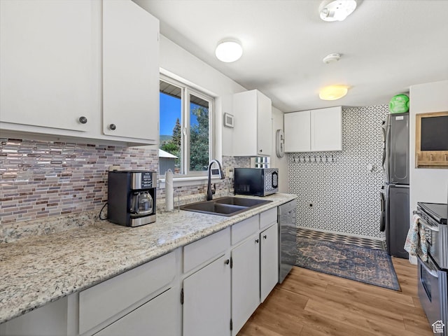 155 Hawthorne, Kamas, UT 84036 - kitchen with stainless steel dishwasher, decorative backsplash, stove, and light wood finished floors
