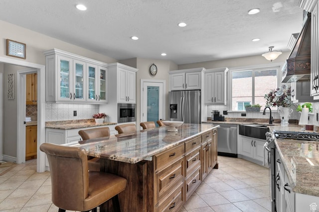 352 E Maple Dr, Alpine, UT 84004 - kitchen with appliances with stainless steel finishes, a breakfast bar, light tile patterned flooring, a center island, and recessed lighting