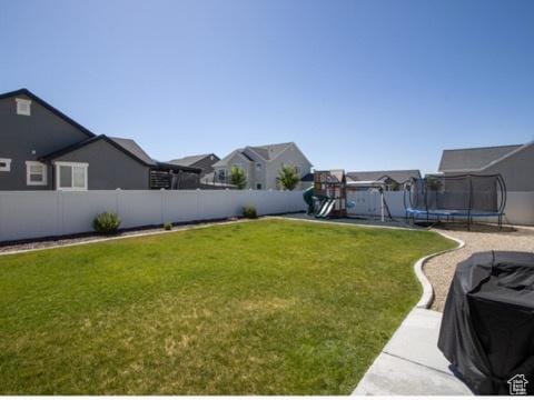 4910 N Deseret Peak Dr, Eagle Mountain, UT 84005 - fenced backyard featuring a trampoline, a playground, and a residential view