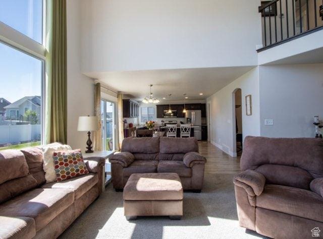 4910 N Deseret Peak Dr, Eagle Mountain, UT 84005 - living area with a towering ceiling, a chandelier, arched walkways, and wood finished floors