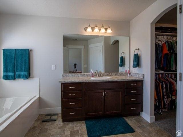 4910 N Deseret Peak Dr, Eagle Mountain, UT 84005 - full bath featuring vanity, a garden tub, and a spacious closet