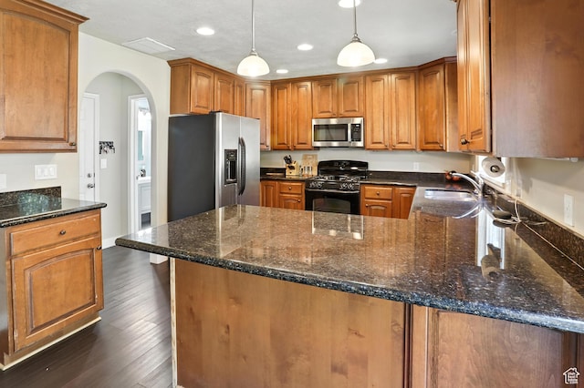 1061 N Bellingham Ct W, North Salt Lake, UT 84054 - kitchen with stainless steel appliances, a peninsula, recessed lighting, arched walkways, and brown cabinets