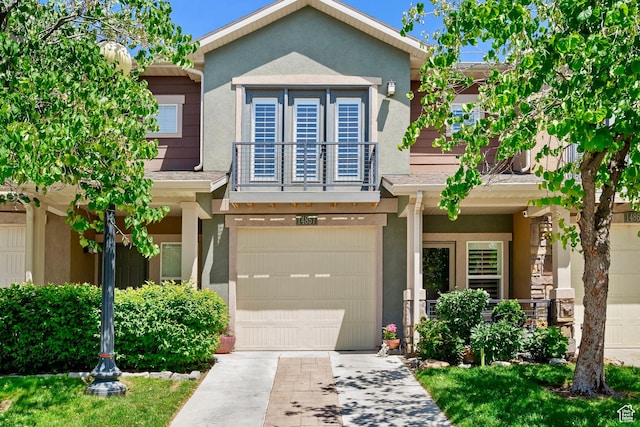 14857 S Treseder St, Draper, UT 84020 - view of front of home with driveway, an attached garage, stucco siding, and a balcony