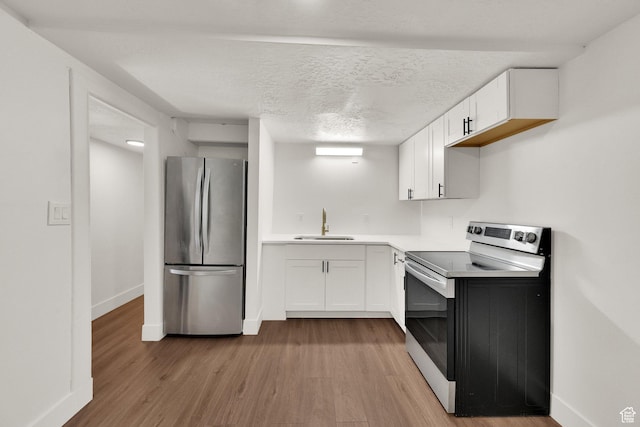 468 W 2400 S, Bountiful, UT 84010 - kitchen featuring appliances with stainless steel finishes, light wood finished floors, white cabinetry, light countertops, and a textured ceiling