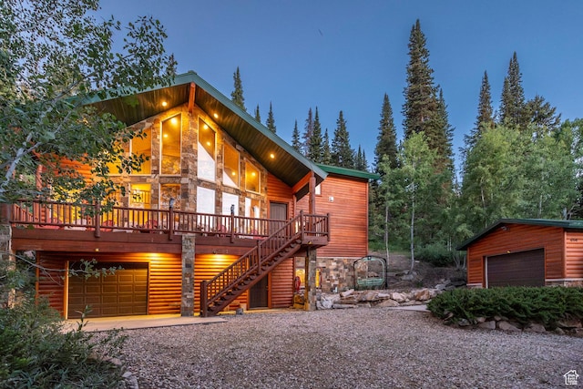 654 Sugar Pine Dr, Oakley, UT 84055 - view of front of home with stone siding, an attached garage, a deck, and stairway