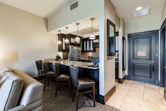 2100 W Frostwood Blvd Unit 3164, Park City, UT 84098 - kitchen featuring built in fridge, a kitchen bar, decorative backsplash, light stone counters, and a peninsula