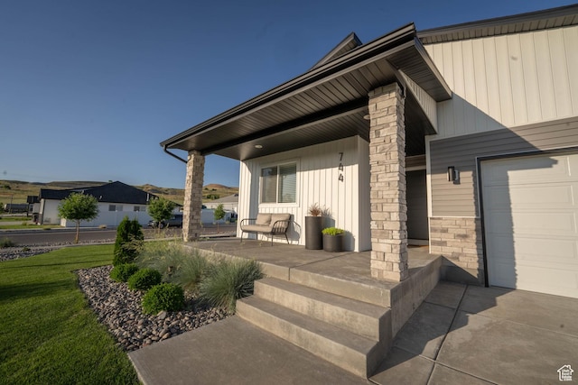 744 N 540 E, Smithfield, UT 84335 - doorway to property with a porch, a garage, a lawn, and board and batten siding