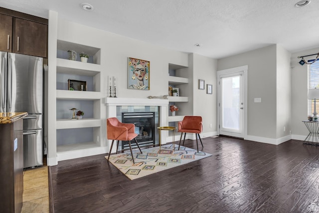 169 W Barry Links Way S, Salt Lake, UT 84115 - living area with built in features, wood finished floors, a textured ceiling, a tiled fireplace, and recessed lighting