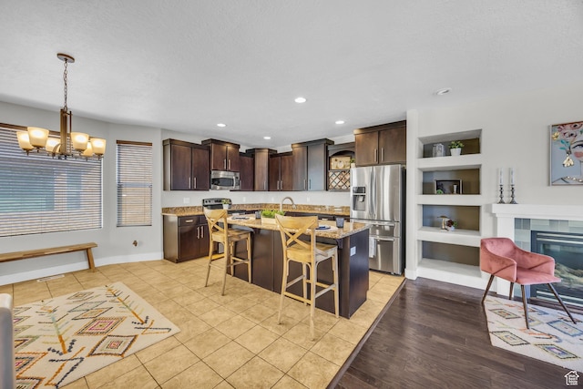 169 W Barry Links Way S, Salt Lake, UT 84115 - kitchen with stainless steel appliances, open shelves, dark brown cabinets, a breakfast bar area, and recessed lighting