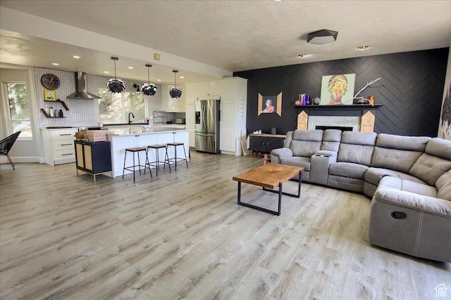2839 S Oakwood Dr, Bountiful, UT 84010 - living area featuring healthy amount of natural light, an accent wall, light wood-type flooring, a textured ceiling, and recessed lighting
