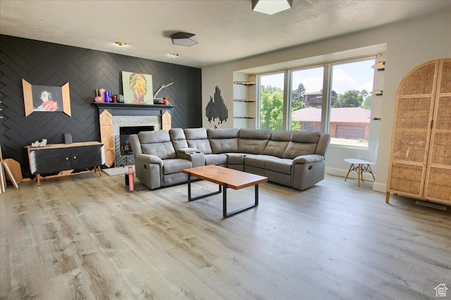 2839 S Oakwood Dr, Bountiful, UT 84010 - living area with an accent wall, wood finished floors, a fireplace with raised hearth, and a textured ceiling