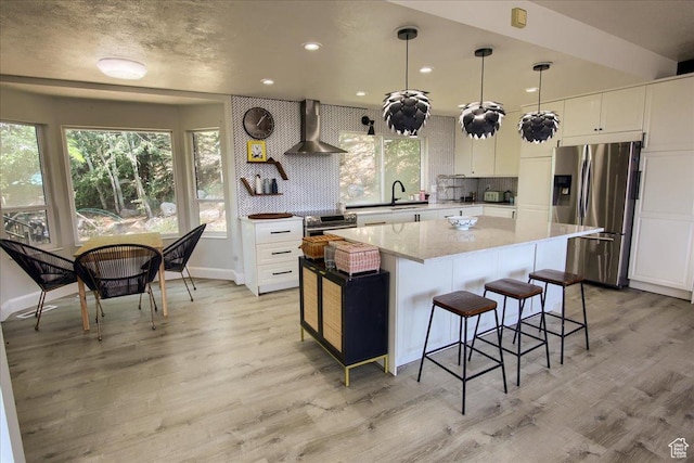 2839 S Oakwood Dr, Bountiful, UT 84010 - kitchen with appliances with stainless steel finishes, wall chimney exhaust hood, healthy amount of natural light, a kitchen island, and recessed lighting