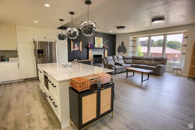 2839 S Oakwood Dr, Bountiful, UT 84010 - kitchen featuring light wood finished floors, white cabinets, stainless steel fridge, a fireplace, and recessed lighting