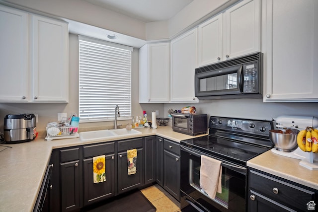 452 N Kent Dr, North Salt Lake, UT 84054 - kitchen with black appliances, white cabinets, light countertops, light tile patterned floors, and dark cabinets