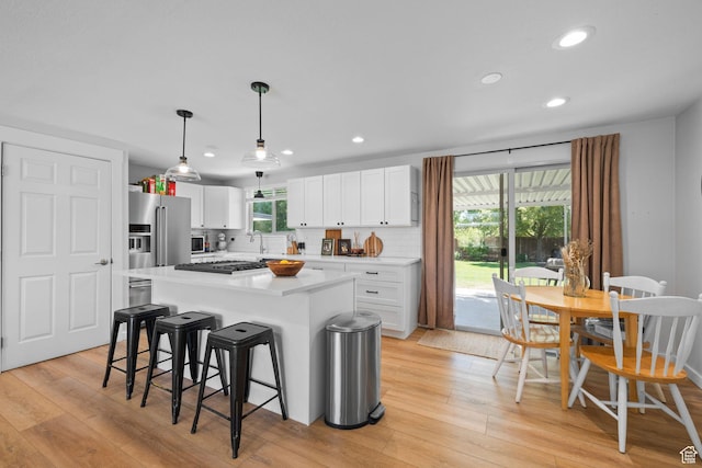 440 E Willow Ave, Murray, UT 84107 - kitchen with light wood finished floors, recessed lighting, appliances with stainless steel finishes, white cabinetry, and a breakfast bar