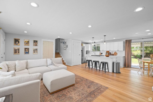 440 E Willow Ave, Murray, UT 84107 - living room with recessed lighting, plenty of natural light, light wood finished floors, and stairs