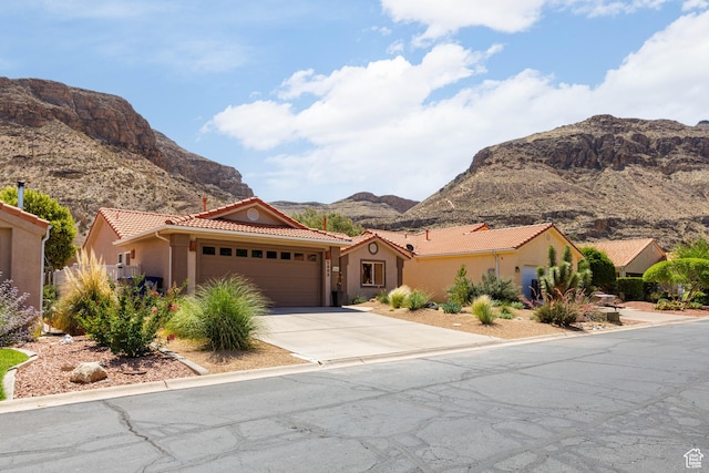 2403 S 725 W, Hurricane, UT 84737 - mediterranean / spanish-style home featuring a tiled roof, a mountain view, a garage, driveway, and stucco siding