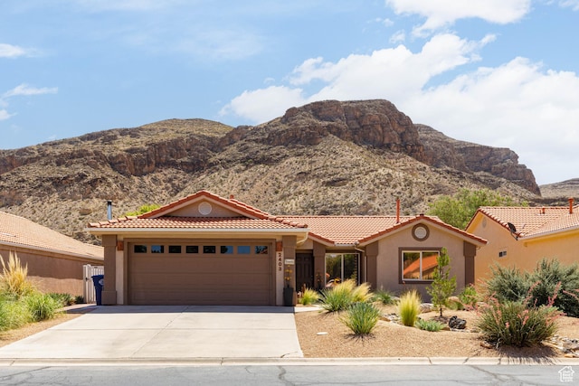 2403 S 725 W, Hurricane, UT 84737 - mediterranean / spanish-style home featuring a tile roof, concrete driveway, a garage, a mountain view, and stucco siding