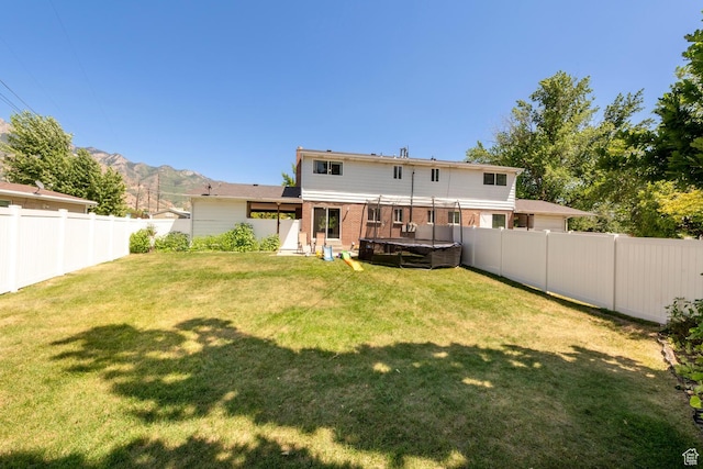 1949 E Jeremy Dr S, Salt Lake City, UT 84121 - back of property featuring a covered hot tub, a fenced backyard, a mountain view, and brick siding