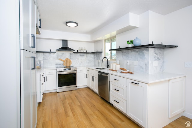 522 W 1060 N, Clinton, UT 84015 - kitchen featuring open shelves, appliances with stainless steel finishes, wall chimney exhaust hood, light wood finished floors, and white cabinetry