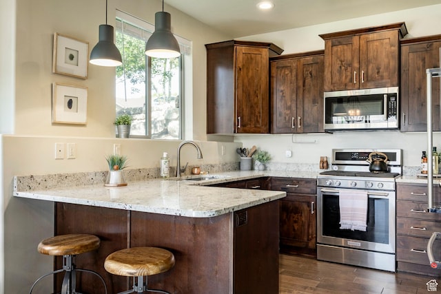 1261 W Black Rock Trl Unit 39D, Kamas, UT 84036 - kitchen featuring appliances with stainless steel finishes, a peninsula, light stone counters, dark wood-type flooring, and a kitchen breakfast bar
