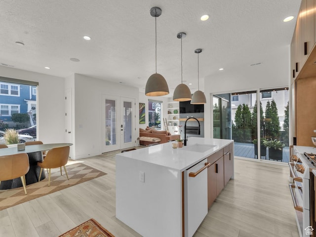 11609 S Dorian Dr W, South Jordan, UT 84009 - kitchen featuring white appliances, a textured ceiling, light wood finished floors, light countertops, and a kitchen island with sink